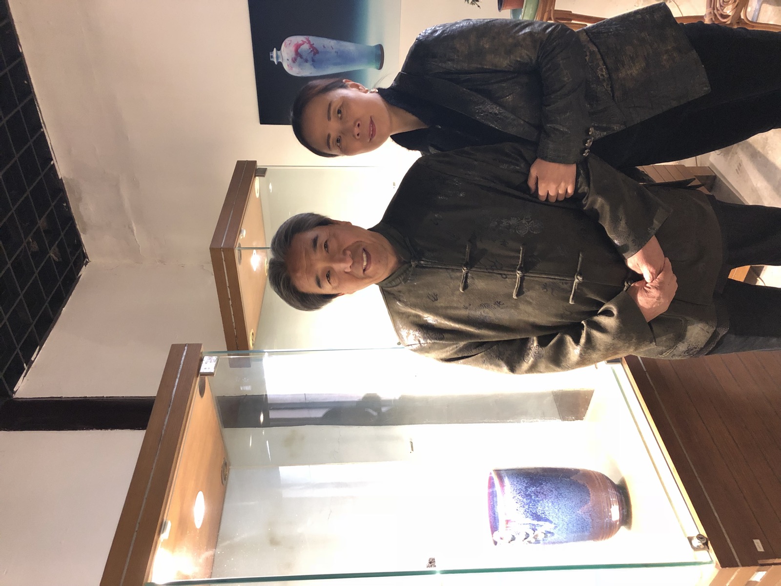 与任星航先生在钧瓷展柜前合影,身后为经典钧瓷瓶作品